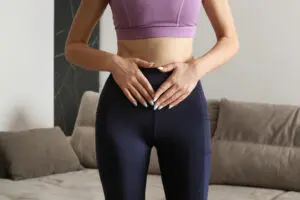 A woman holding her pelvis during menstrual cramps
